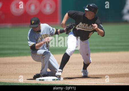27 juin 2010 - Oakland, Californie, États-Unis - 27 juin 2010 : Oakland Athletics SS Cliff Pennington (2) glisse en troisième base comme la balle est par Pittsburgh Pirates si Andy LaRoche (15) au cours de la MLB Interleague match entre les Athletics d'Oakland et les Pirates de Pittsburgh au Oakland-Alameda County Coliseum à Oakland, CA. La visite de pirates est tombé à l'Athlétisme 3-2. (Crédit de droit Banque D'Images
