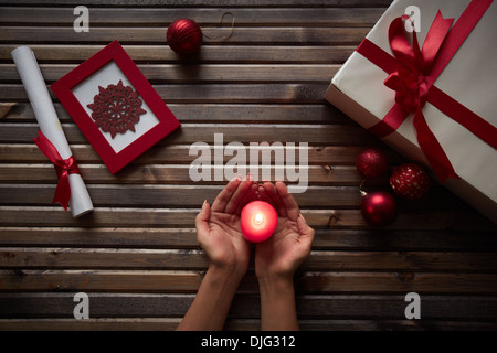 Image des femmes hands holding bougie allumée entourée de symboles de Noël Banque D'Images