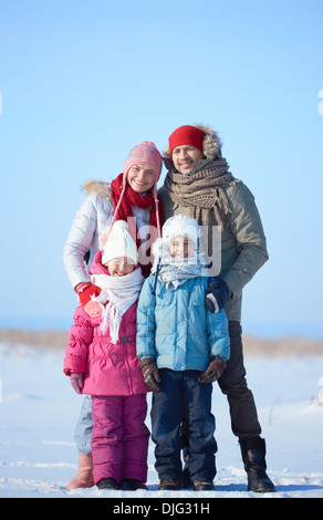 Heureux les parents et leurs enfants à l'extérieur de l'appareil photo à winterwear Banque D'Images