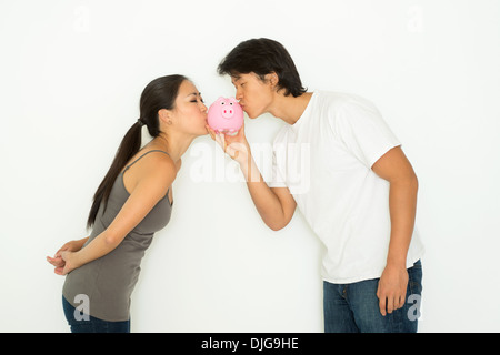 A Young Asian Woman holding a piggy bank et il s'embrasser, un plan d'épargne financière concept. Banque D'Images