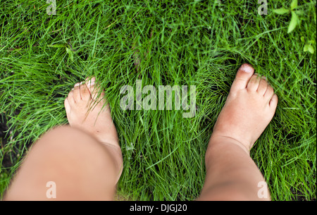 Petit bébé pieds sur l'herbe verte. Banque D'Images