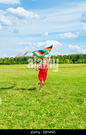 Cute little girl 6 ans avec des cheveux blonds exécutant holding kite dans le domaine de l'été journée ensoleillée Banque D'Images