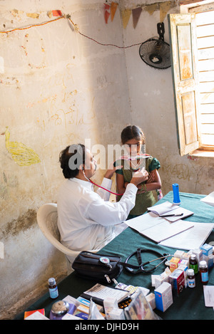 Médecin Pédiatrie indien l'examen d'une jeune fille à Sri Sathya Sai Baba mobiles de proximité hôpital clinique. L'Andhra Pradesh, Inde Banque D'Images