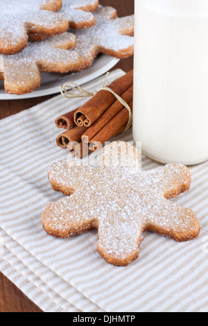 Les cookies en forme de flocon décoré avec du sucre en poudre et une bouteille de lait Banque D'Images