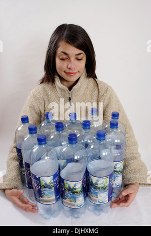 Teenage girl holding veste polaire en douze grandes bouteilles en plastique Banque D'Images