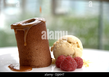 Gâteau au chocolat avec le caramel et sorbet banane et framboises Banque D'Images