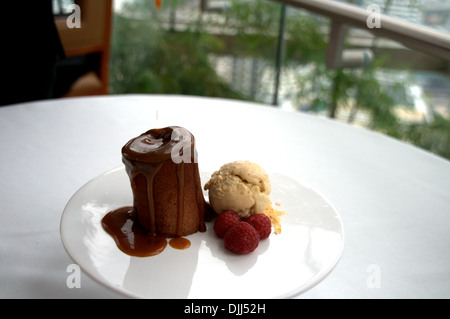 Gâteau au chocolat avec le caramel et sorbet banane et framboises Banque D'Images