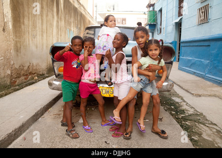 Les enfants cubains jouant dans un groupe dans la rue dans un quartier pauvre de La Havane, Cuba Caraïbes Banque D'Images