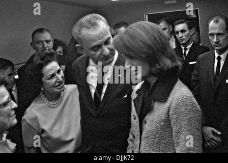 Le président américain Lyndon B. Johnson parle avec Jacqueline Kennedy après son assermentation en tant que président par le juge Sarah Hughes après la mort de John F. Kennedy à bord d'Air Force One le 22 novembre 1963 à Dallas, Texas. Lady Bird Johnson est sur la gauche. Banque D'Images