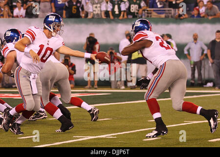 16 août 2010 - Rutherford, New Jersey, États-Unis d'Amérique - Août 16, 2010 : New York Giants quarterback ELI MANNING (# 10) les mains hors de running back BRANDON JACOBS (# 27). New York Jets conduire les Giants de New York 13-10 à la demie, à jouer au cours de la pré-saison match joué au stade de New Meadowlands Rutherford, New Jersey. Crédit obligatoire : Anthony Gruppuso / Southcreek G Banque D'Images