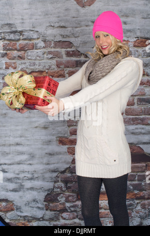Heureux Jeune femme confiante, de la détention et de la valeur comptable ou de Cadeaux de fête de Noël pour la famille et les amis, sur un fond bleu Banque D'Images