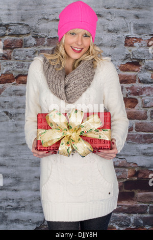 Heureux Jeune femme confiante, de la détention et de la valeur comptable ou de Cadeaux de fête de Noël pour la famille et les amis, sur un fond bleu Banque D'Images