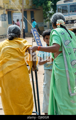 Vieille Femme indienne d'être aidé de Sri Sathya Sai Baba mobiles de proximité hôpital clinique. L'Andhra Pradesh, Inde Banque D'Images