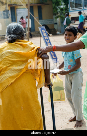 Vieille Femme indienne d'être aidé de Sri Sathya Sai Baba mobiles de proximité hôpital clinique. L'Andhra Pradesh, Inde Banque D'Images