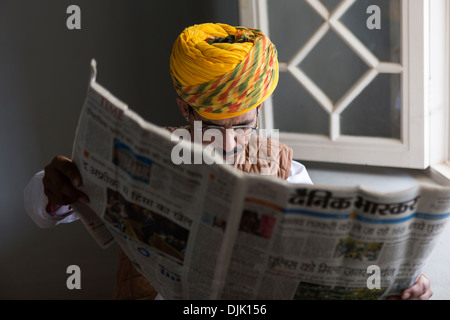 L'un des travailleurs de la Mehrangarh Fort lit le journal. Banque D'Images