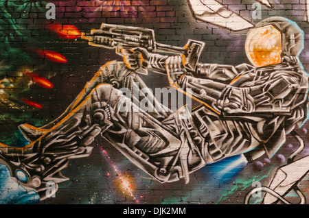 Graffitis colorés dans des Elllum représentant un astronaute d'un fusil de tir de combat dans l'espace. Dallas, Texas. Banque D'Images