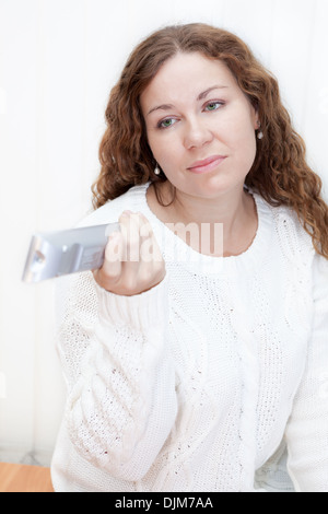 Fille avec aigreur face à des changements de contrôle à distance de la télévision satellite Banque D'Images