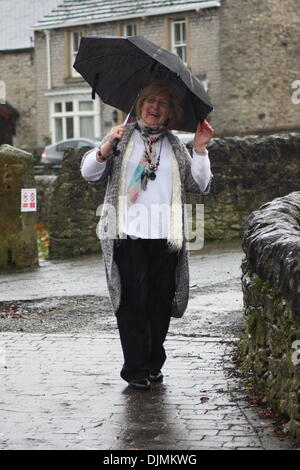 Bradwell, Derbyshire, Royaume-Uni. 29 novembre 2013. Et un vent soufflant la pluie qui rebondit dans le Derbyshire Peak District ne parviennent pas à refroidir l'enthousiasme de 80 ans Betty Bromley car elle va à propos de son entreprise dans Bradwell, le lieu de naissance de Samuel Fox - inventeur de l'acier nervurée-parapluie. Credit : Matthew Taylor/Alamy Live News Banque D'Images