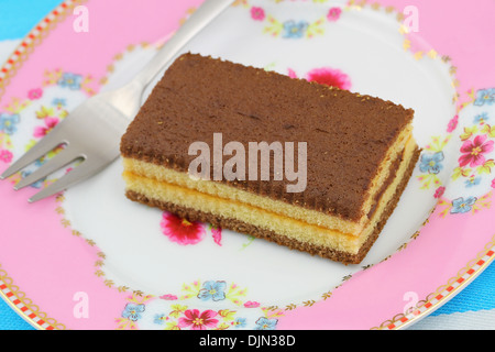 Le caramel et chocolat gâteau sur une plaque vintage rose Banque D'Images