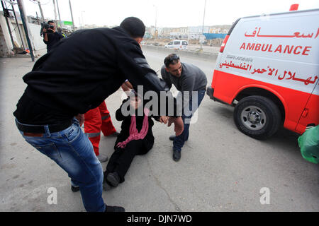 Qalandiya, Cisjordanie, territoire palestinien, . 29 nov., 2013. Les médecins palestiniens traiter une femme souffre de gaz lacrymogènes tirés par les forces de sécurité israéliennes au cours d'affrontements à la suite d'une manifestation contre l'assassinat de Mahmoud Waji Awad, un Palestinien qui est mort la veille de ses blessures après qu'il a été tourné en 2012 un affrontement avec les troupes israéliennes, au poste de contrôle de Qalandiya près de la ville de Ramallah, en Cisjordanie, le 29 novembre 2013 Crédit : Issam Rimawi APA/Images/ZUMAPRESS.com/Alamy Live News Banque D'Images