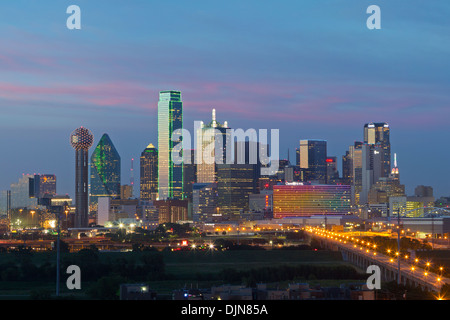 Le Dallas skyline commence à s'allumer sur une chaude soirée d'été. Dans la ligne d'horizon est la fameuse Reunion Tower. Banque D'Images