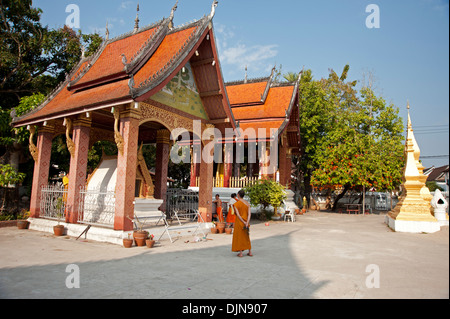 Les moines bouddhistes de marcher autour d'un temple à Luang Prabang au Laos Banque D'Images