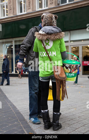 Oxfam Charity Workers, Street collectioning à Liverpool, Merseyside, Royaume-Uni, 29 novembre 2013.Une femme Oxfam Chugger demande des dons dans un centre-ville de Liverpool.La saison des achats des fêtes, les magasins de détail, les magasins. Banque D'Images