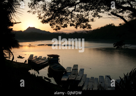 Les soleils se couche derrière les montagnes sur le Mékong à Luang Prabang au Laos Banque D'Images