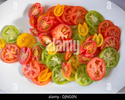 Les tomates de différentes couleurs sur un plateau blanc Banque D'Images