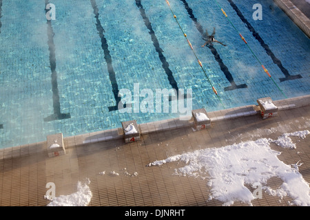 Femme nage dans la piscine extérieure en hiver Banque D'Images