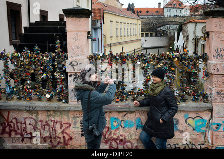 Un couple sur le pont des amoureux. Prague. Pas aussi flashy ou connu comme le grand pont Charles, Prague amour résidents mais ce charmant petit pont en treillis, presque dans le camouflage moins connue de la superbe vieille ville et à seulement 20 mètres est capable de franchir avec confiance extrême rien de plus et rien de moins que le canal del Diablo. L'ancien Prieuré de pont, où encore aujourd'hui vous pouvez voir la vieille roue du moulin, Elf a sa propre eau et quelques années est le lieu de prédilection pour les amateurs de fermer ses écluses sur le SENAR amour éternel. Banque D'Images