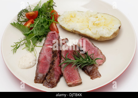 Tranches de bœuf wagyu gastronomique-eye steak servi avec sauce au raifort, une pomme de terre au four et une salade verte fraîche Banque D'Images