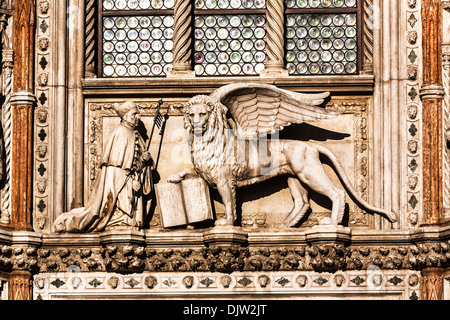 Détail d'un lion ailé avec un livre ouvert au-dessus de la Porta della Carta entrée du palais des Doges, Venise, Vénétie, Italie. Banque D'Images