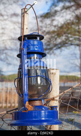 Vintage bleu lampe à kérosène se bloque sur la vieille clôture en plein air Banque D'Images