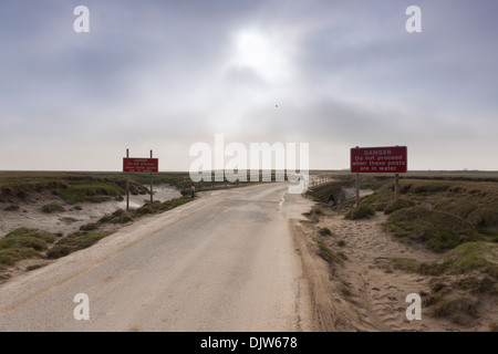 Avertissement sur une route qui est couvert lorsque la marée monte Banque D'Images