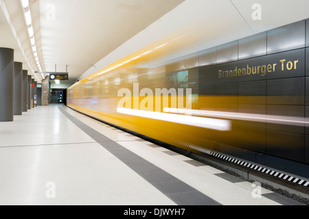 Un train de métro jaune laissant Brandenburger Tor gare de Berlin, Allemagne. Banque D'Images