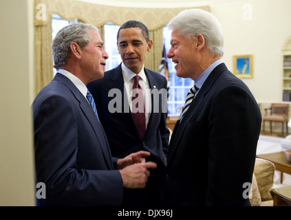 Le président américain Barack Obama regarde l'ancien président George W. Bush des blagues avec l'ancien Président Bill Clinton dans le bureau ovale de la Maison Blanche le 16 janvier 2010 à Washington, DC. Le président Obama a demandé aux deux anciens Présidents de l'aide pour le séisme en Haïti. Banque D'Images