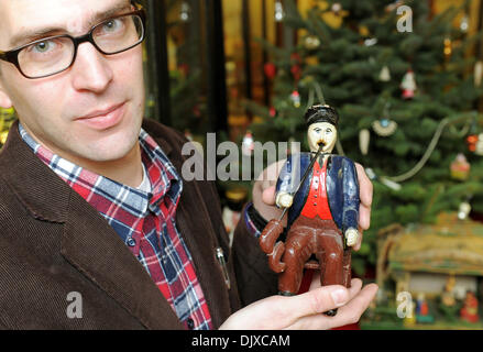 Klessen, Allemagne. 27 nov., 2013. Le directeur du musée, Firthjof Hahn est titulaire d'un homme fumeur sculpté du début du xxe siècle une partie de l'exposition de Noël au musée du jouet à Klessen, Allemagne, 27 novembre 2013. Le musée du jouet dans le Havelland est ouvert à partir du 01 décembre jusqu'au 22 décembre. Photo : Bernd Settnik/dpa/Alamy Live News Banque D'Images