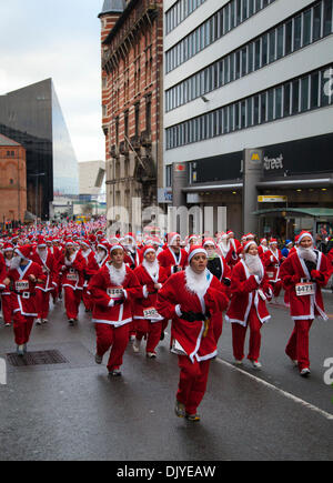 Liverpool, Merseyside, Royaume-Uni. 1er décembre 2013. Les coureurs de la rue James à la Liverpool Santa Dash à partir de la jetée tête et essayer de battre le record mondial Guinness pour le plus grand rassemblement "Santa" qui se situe à moins de 13 000 et aussi essayer d'élever à plus de dernières années total de €5 millions. Festive Fun Run est l'appui du texte de TVI Santa Appel cette année pour aider à recueillir des fonds pour l'âge UK, Anthony Nolan, soignants UK, Marie Curie Cancer Care, ensemble pour de courtes vies et Whizz-Kidz. Banque D'Images