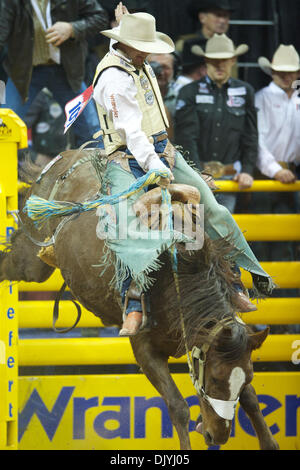 Le 3 décembre 2010 - Las Vegas, Nevada, United States of America - saddle bronc rider Dustin Flundra de Pincher Creek, Alberta, Canada rides Théorie des dominos pour une note de 78,00 Au cours de la seconde à la Wrangler 2010 National Finals Rodeo au Thomas & Mack Center. (Crédit Image : © Matt Cohen/ZUMAPRESS.com) Southcreek/mondial Banque D'Images