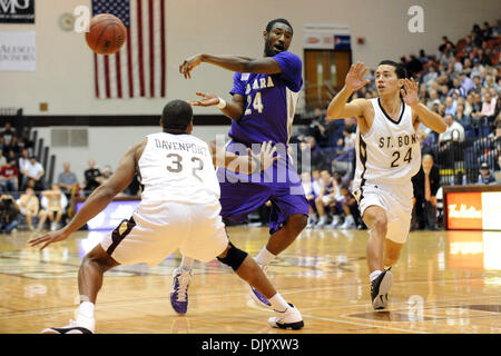 Le 12 décembre 2010 - Saint Bonaventure, New York, États-Unis d'Amérique - Niagara Purple Eagles guard Kevon Moore (24) vaisselle le no-look pass lors de la tentative de diviser la défense de saint Bonaventure Bonnies guard Michael Davenport (32) et saint Bonaventure Bonnies guard Matthew Wright (24) dans la première moitié. Défait Niagara Saint Bonaventure 69-61 pour gagner leur huitième contre détroit la Bonn Banque D'Images