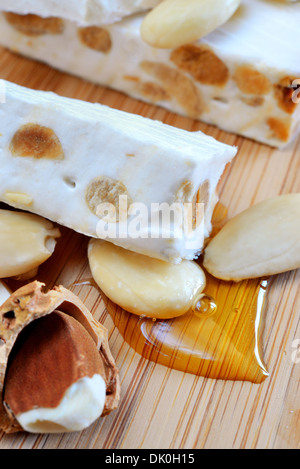 Le miel blanc doux nougat aux amandes sur une planche à découper Banque D'Images