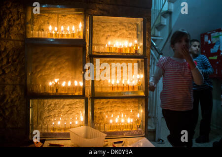 Sanhedria, Jérusalem, Israël. 1er décembre 2013. Les enfants jouent à une entrée du bâtiment en plus d'un lot d'Hanukkiot, huit branches menorahs, allumé avec cinq bougies célébrant le cinquième de huit nuits de Hanoukka. Jérusalem, Israël. 1-Dec-2013. Le hassidisme Bratslav, ultra-orthodoxes, Yeruslavski, la famille lumière cinq bougies sur les huit branches de la menorah célébrant la cinquième nuit de Hanoukka, commémorant la lampe à pétrole qui ont miraculeusement brûlé pendant huit jours dans le Temple détruit en 164 BCE. Credit : Alon Nir/Alamy Live News Banque D'Images