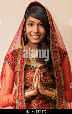 Portrait d'une belle femme indienne habillés en vêtements traditionnels holding hands in Namaste geste.