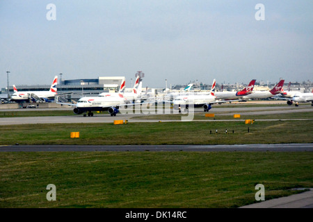 Ligne d'avions en attente de décollage de l'aéroport de Londres Heathrow sur un matin occupé Banque D'Images