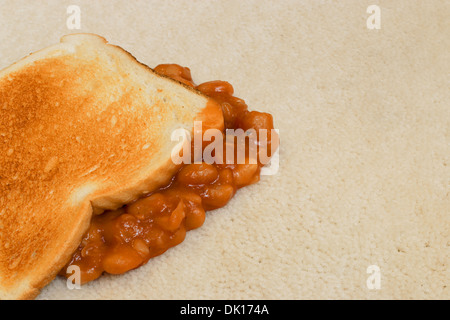 Les haricots sur toast une chute accidentelle et la création d'une tache sur tapis de sol velours beige Banque D'Images