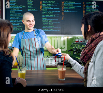 Carte de crédit de recevoir du barman de paiement client in cafe Banque D'Images