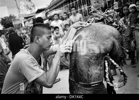 San Fernando Pampanga, Philippines ; - le 29 mars 2013 : bâton en bois avec des verres brisés est frappé à l'arrière de pénitents Banque D'Images