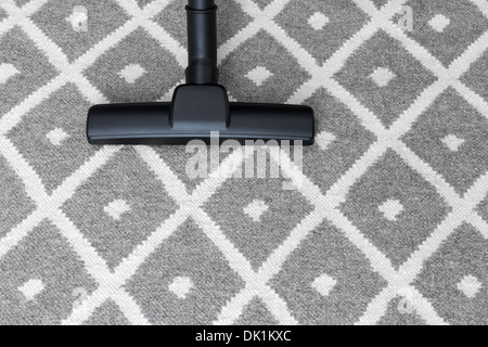 Travaux ménagers. Aspirateur sur moquette grise. Banque D'Images