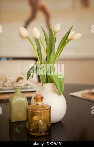 Tulipes blanches dans un vase sur une table à manger Banque D'Images